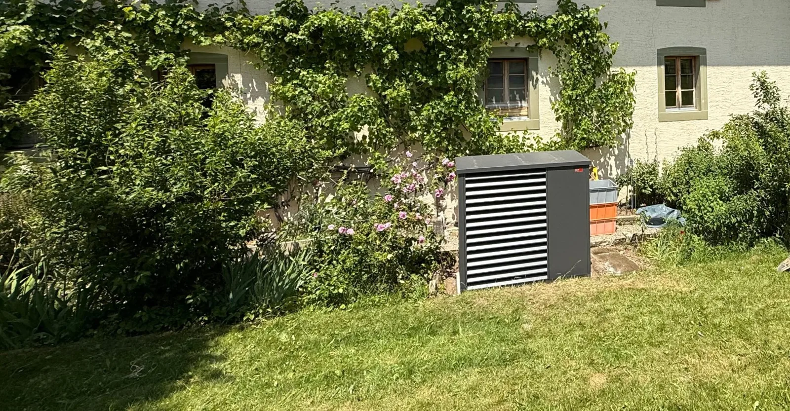 Pompe à chaleur au jardin, contre la façade