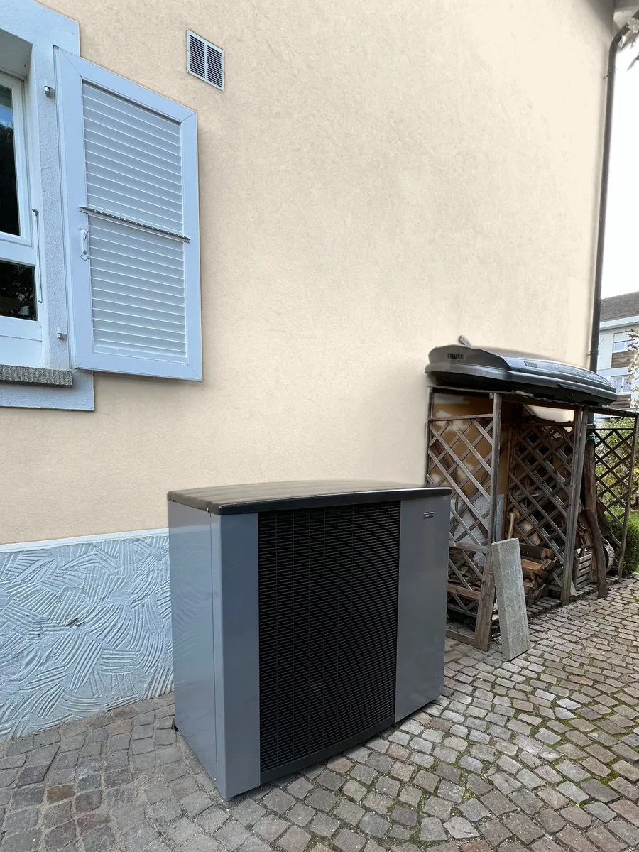 Pompe à chaleur air/eau monobloc posée contre la façade, sur pavés